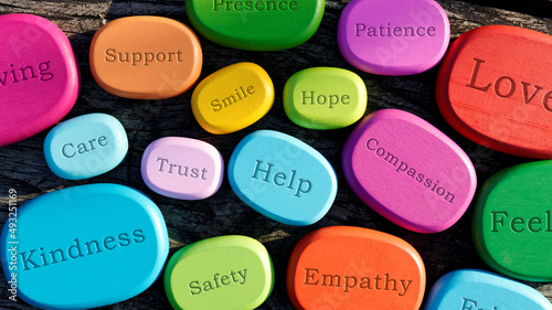 Supportive and kind words written on colorful wooden stones. Helping attitude concept.