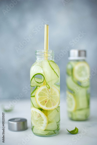 detox water with cucumber, lemon and mint in a tall glass bottle