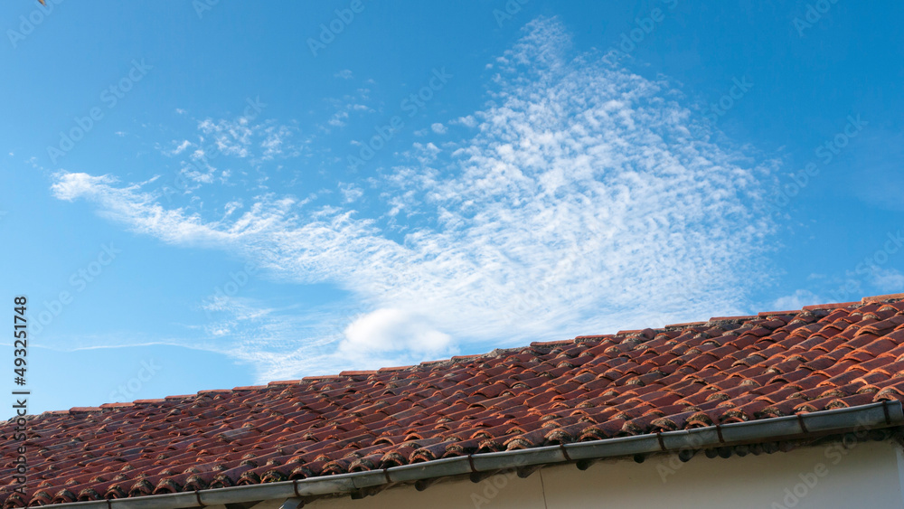 Tejado de tejas de barro en casa rural y nube en el cielo
