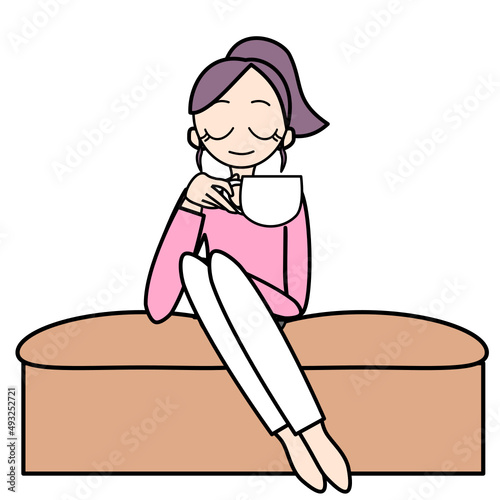 ソファに座り飲み物を飲む女性
