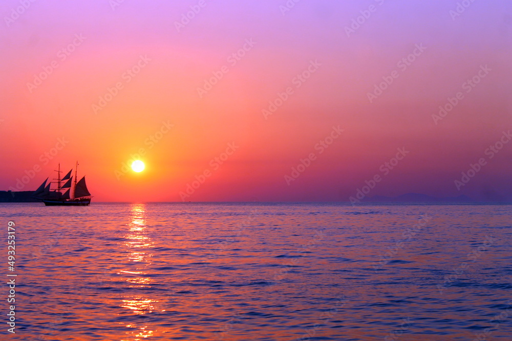 Purple vessel sunset on the infinite ocean with the reflections on the water