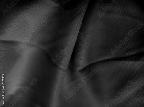 black satin texture with a glossy and wavy smooth surface. folded surface