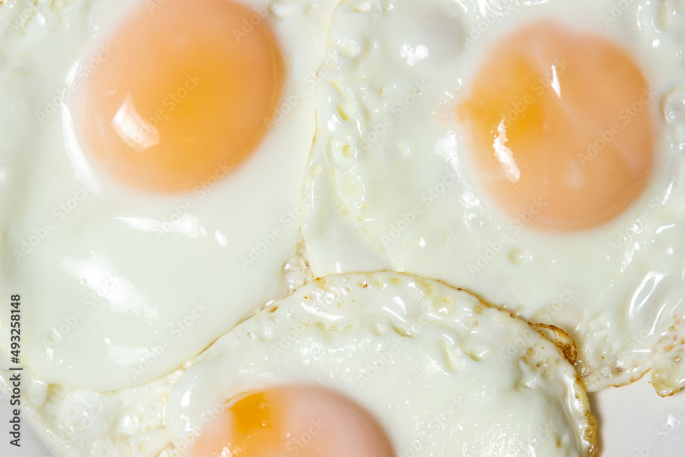 Close-up scrambled eggs. Three fried eggs on a plate. Quick and tasty breakfast Close-up scrambled eggs. Three fried eggs on a plate. Quick and tasty breakfast