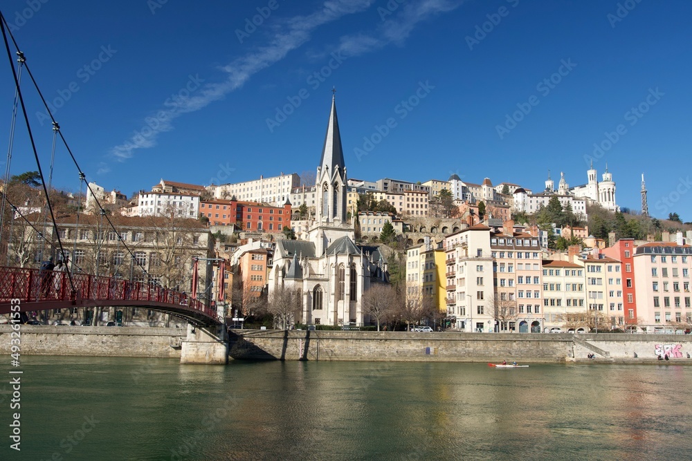 Panorama of old lyon in France with in the foreground the river Saône, the Saint George church, the Saint George footbridge , and the basilica Notre Dame de fourvière on the heights at sunrise.