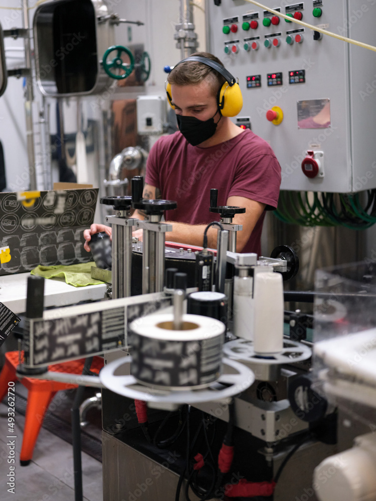 Man working packing beer cans in a factory