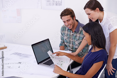 Three heads are better than one. Shot of a group of young architects working together in the office. photo