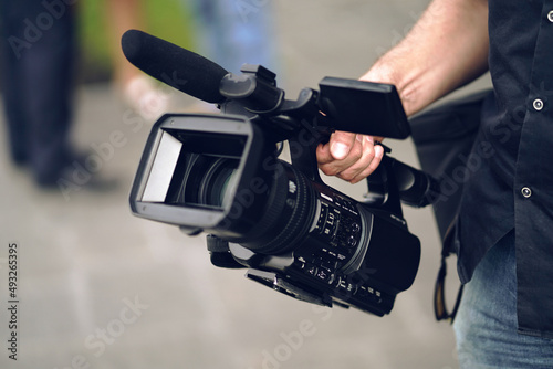 The camcorder is in the hands of the operator, the blurred background