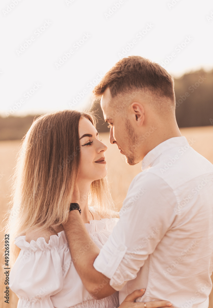 Handsome guy and blonde girl walking on the field of wheat on a beautiful warm sunset. Handsome guy and blonde girl walking on the field of wheat on a beautiful warm sunset.