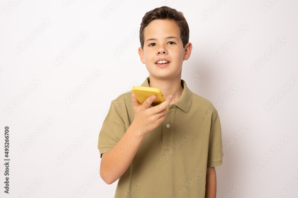 Caucasian boy in green polo shirt using smartphone isolated over white background. Caucasian boy in green polo shirt using smartphone isolated over white background.