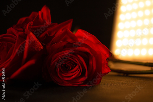 Beautiful photo of red roses on a black background with golden LEDs