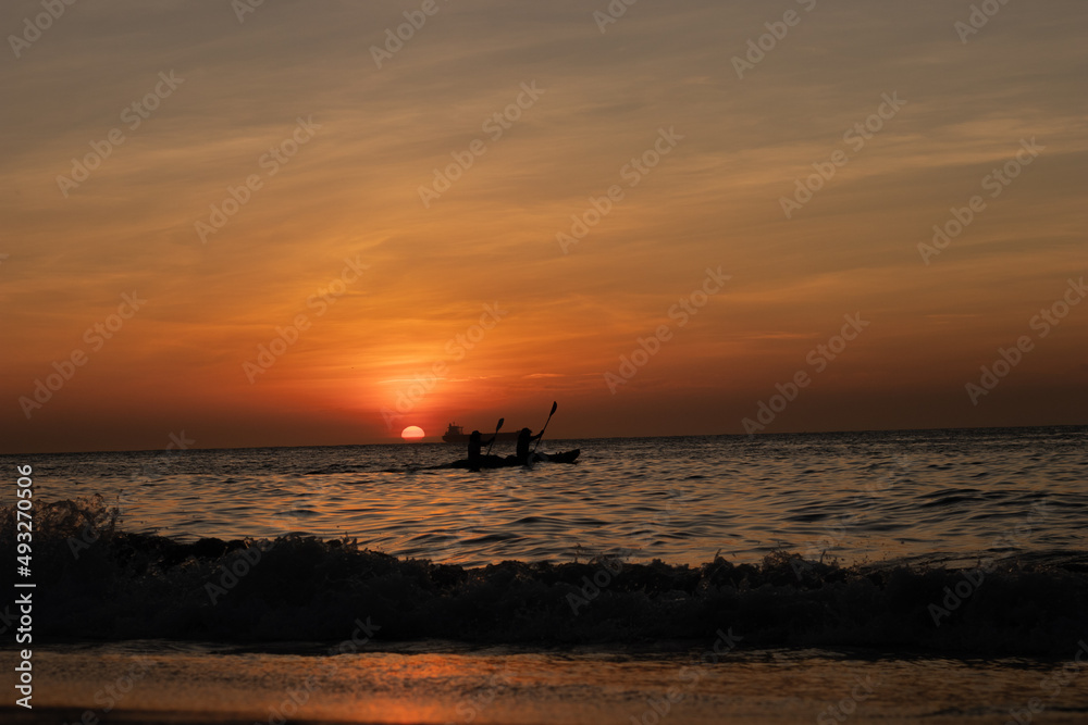 Rowing sport at sunset in the ocean
