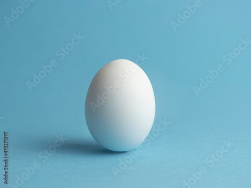 Egg on a blue background. Minimalism. Easter holiday.