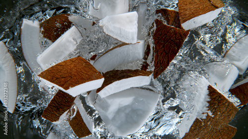 Fresh sliced coconuts falling into water, underwater view. photo