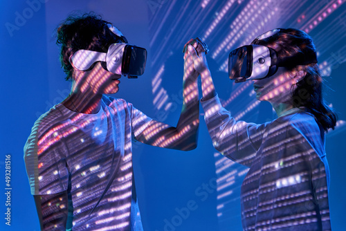 Couple exploring cyberspace under glowing lights photo