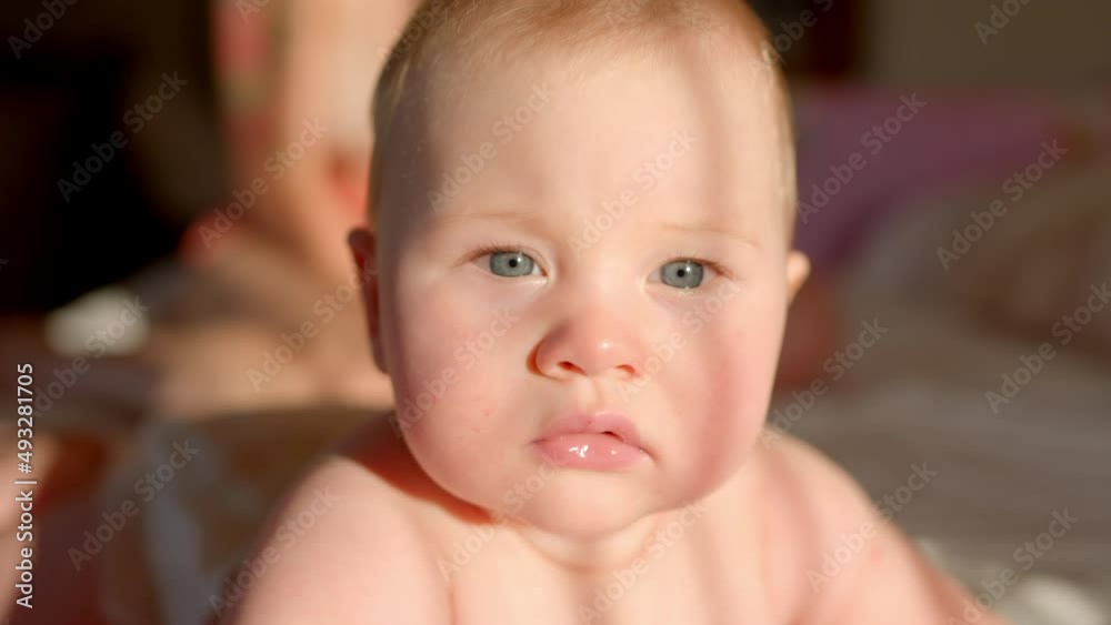 A nice little caucasian newborn baby is funny smiling, lying at the back in the child crib. Portrait of a playful and energetic child close-up, slow motion A nice little caucasian newborn baby is funny smiling, lying at the back in the child crib. Portrait of a playful and energetic child close-up, slow motion