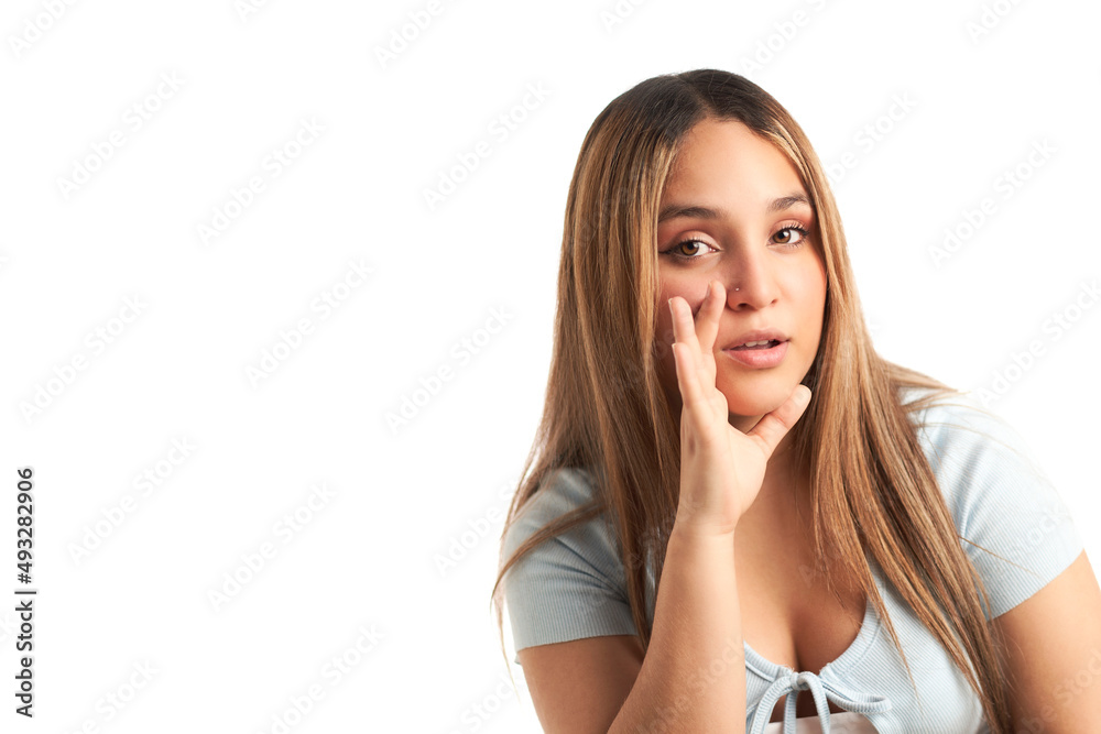 Young Hispanic girl in casual clothes with hand to mouth, telling secret rumors Young Hispanic girl in casual clothes with hand to mouth, telling secret rumors