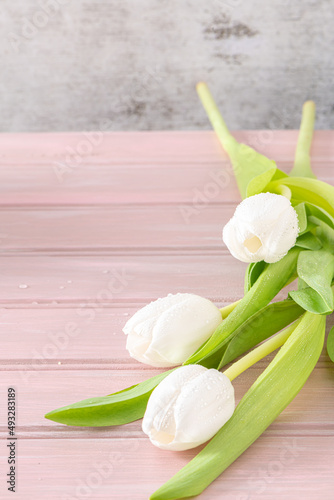 Fototapeta Naklejka Na Ścianę i Meble -  Bouquet of white tulips on pink wooden background.