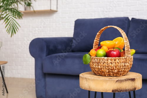 Fototapeta Naklejka Na Ścianę i Meble -  Wicker fruit basket on stool in living room