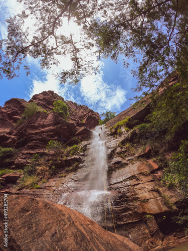 rappelling or torrentism in waterfall descending on ropes