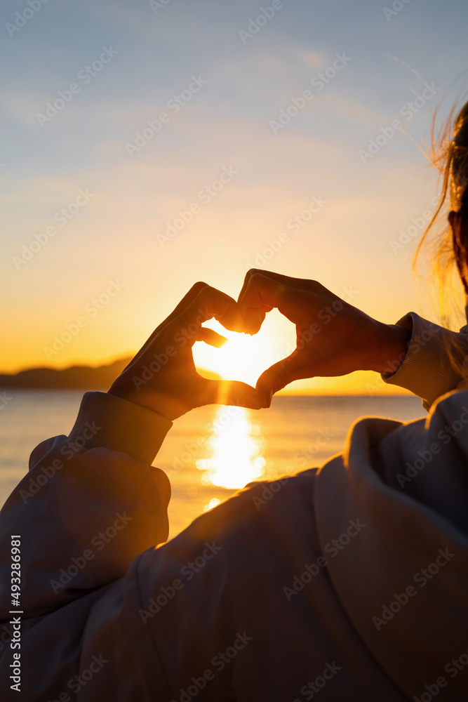 Heart shape with female hands over sunset sky background Stock Photo ...