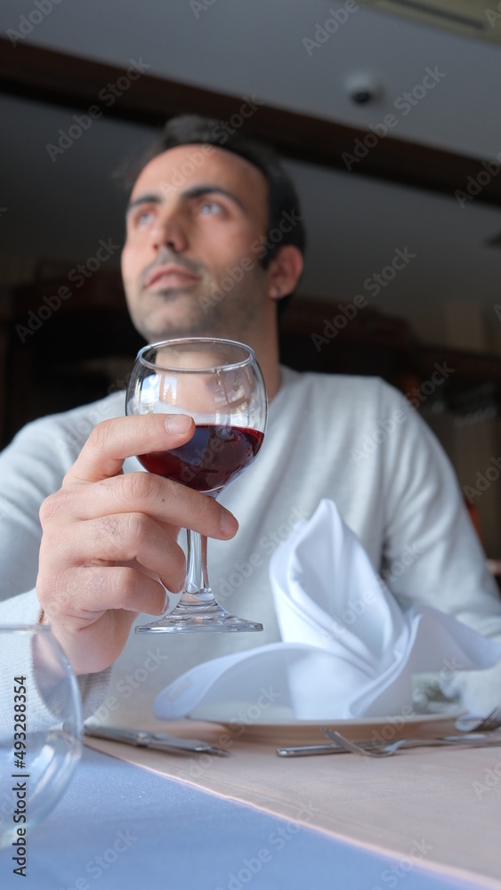 Man drinks wine in minimal luxury restaurant in hotel for summer time. Man drinks wine in minimal luxury restaurant in hotel for summer time.