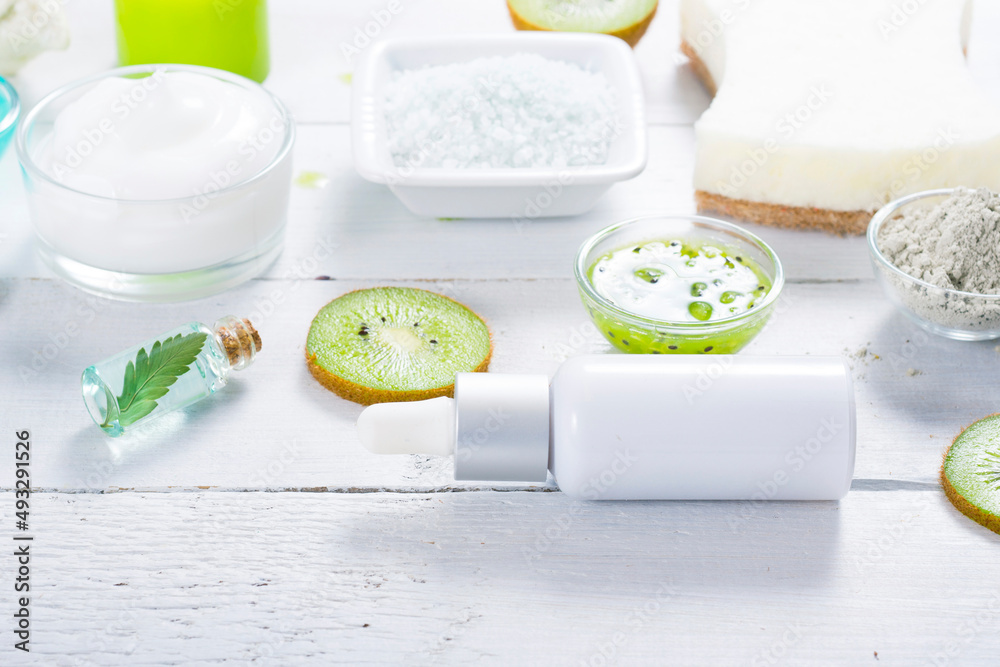 beauty products with kiwi fruit ingredient on white wooden table