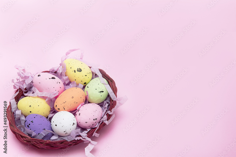 Easter colorful eggs in a basket on a pink background, Easter concept, Easter card