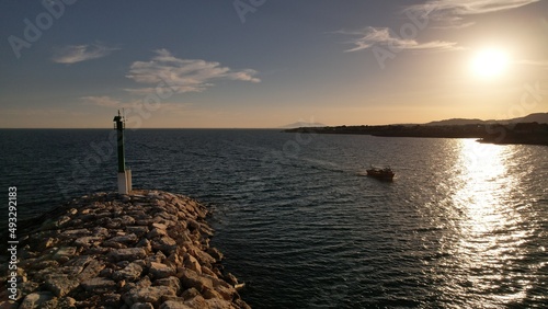 barca de pesca entrando a puerto en un atardecer