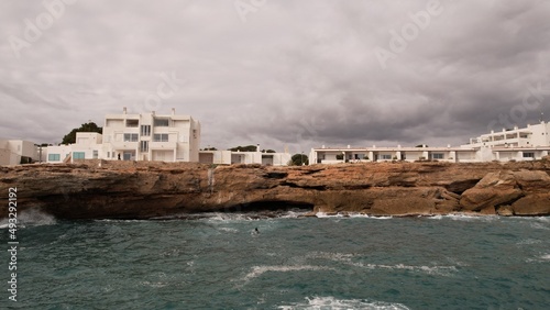 acantilado en el mar, con casa y persona  haciendo un rescate