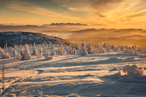 Winter sunset seen from Pilsko in Beskid Żywiecki. Beautiful views of the Tatras and the Mala Fatra massif, bathed in golden light.