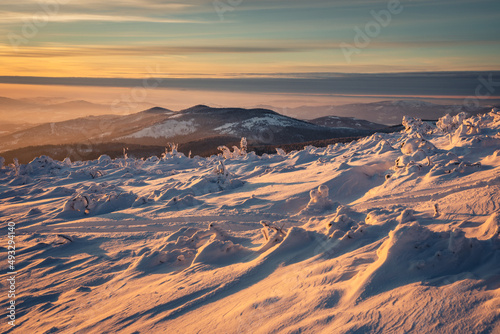 Fototapeta Naklejka Na Ścianę i Meble -  Winter sunset seen from Pilsko in Beskid Żywiecki. Beautiful views of the Tatras and the Mala Fatra massif, bathed in golden light.