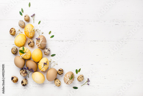 Easter eggs with flowers on a white table.