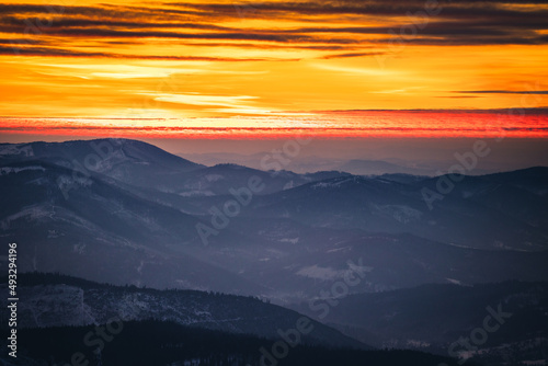 Fototapeta Naklejka Na Ścianę i Meble -  Winter sunset seen from Pilsko in Beskid Żywiecki. Beautiful views of the Tatras and the Mala Fatra massif, bathed in golden light.