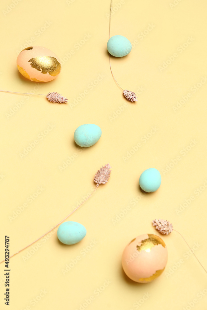 Painted Easter eggs and flowers on yellow background