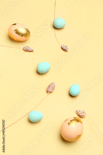 Painted Easter eggs and flowers on yellow background