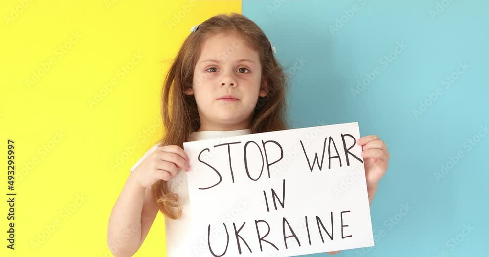 little girl raises banner with inscription stop the war in Ukraine little girl raises banner with inscription stop the war in Ukraine