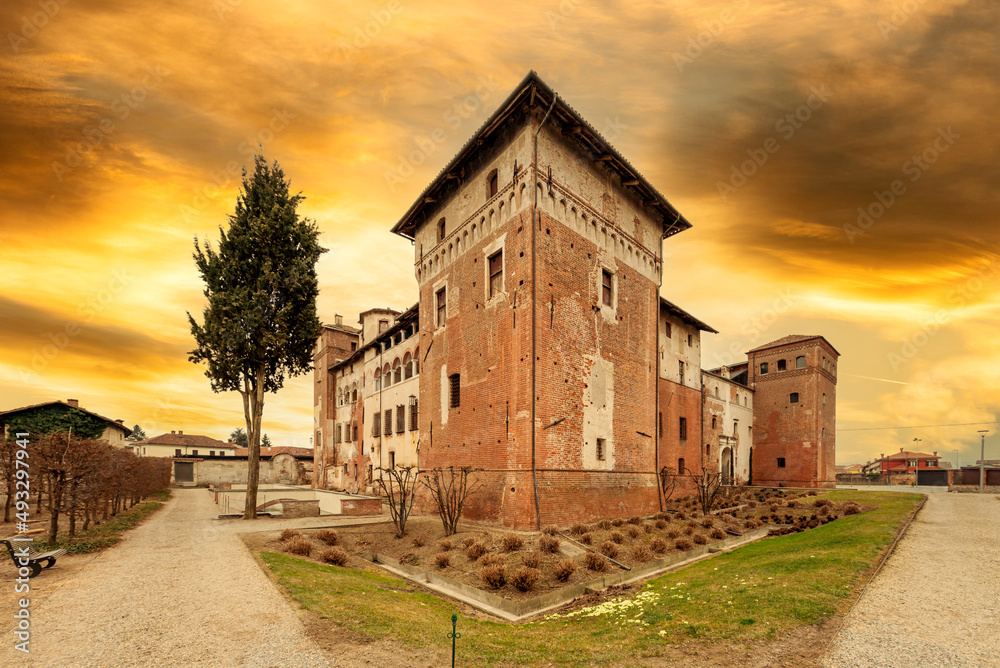 Lagnasco, Cuneo, Italy - March 16, 2022: The Castles of the Marquises Tapparelli D'Azeglio (11th to 18th century) with sky with colored sunset clouds
