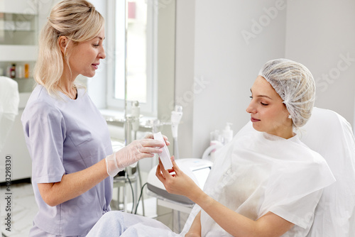 Doctor cosmetologist and patient discussing the drug photo