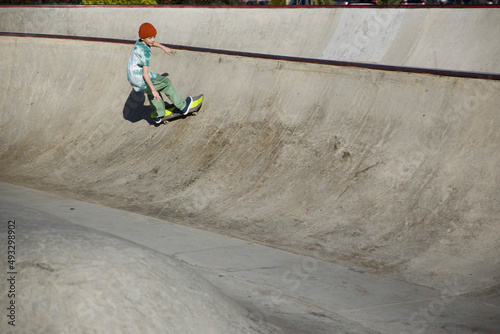 Young skater riding on concrete ramp photo