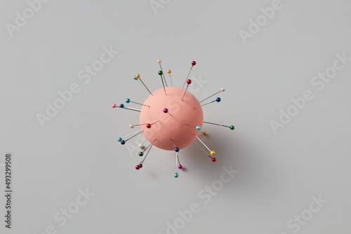 Pins dipped into ball over grey background photo