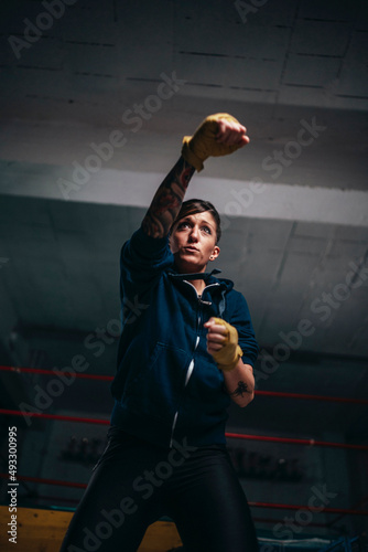 Serious motivated woman boxing in gym