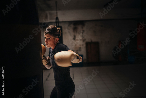 Focused strong woman boxing in gloves photo