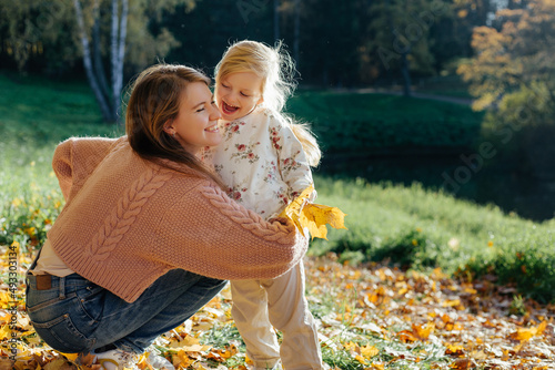 Mother and child hugging in autumn park photo