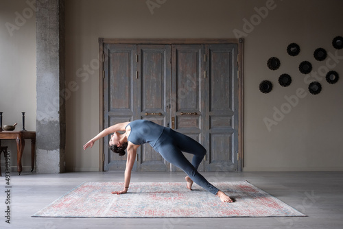 Graceful woman doing Wild Thing pose photo