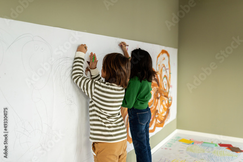 Children drawing modern artwork at studio walls photo