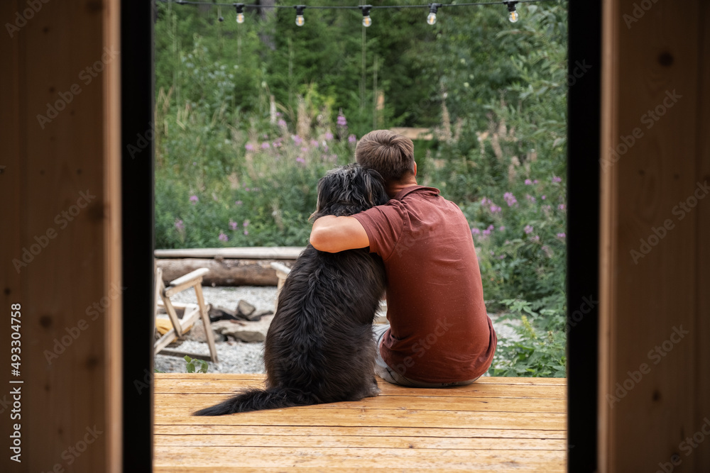 Man hugging dog on house porch Man hugging dog on house porch