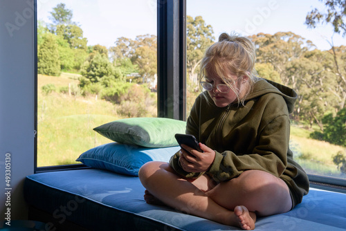 Tween sitting alone using phone photo