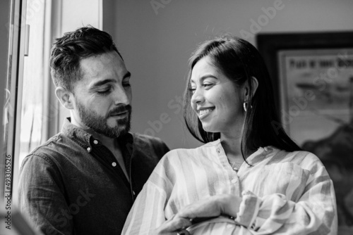 Happy couple in love near the window at home photo