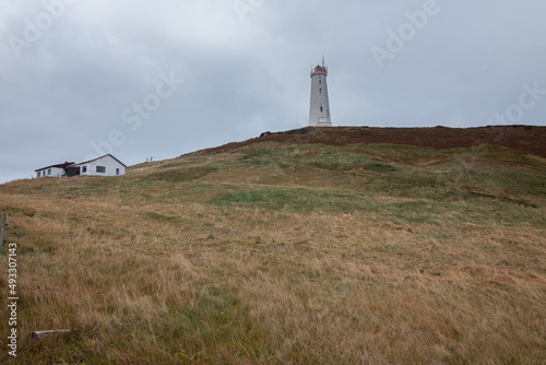 Mountain landscape with a coastal lighthouse and house