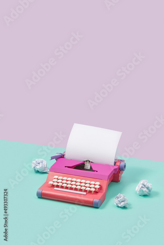 Pink typewriter and crumpled papers photo